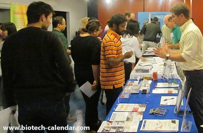Lab supply company representative discussing laboratory research equipment with event attendees