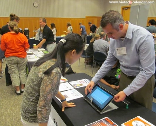 A vendor uses a tablet computer to display new events and laboratory products available at the BioResearch Product Faire™ at the University of Michigan.